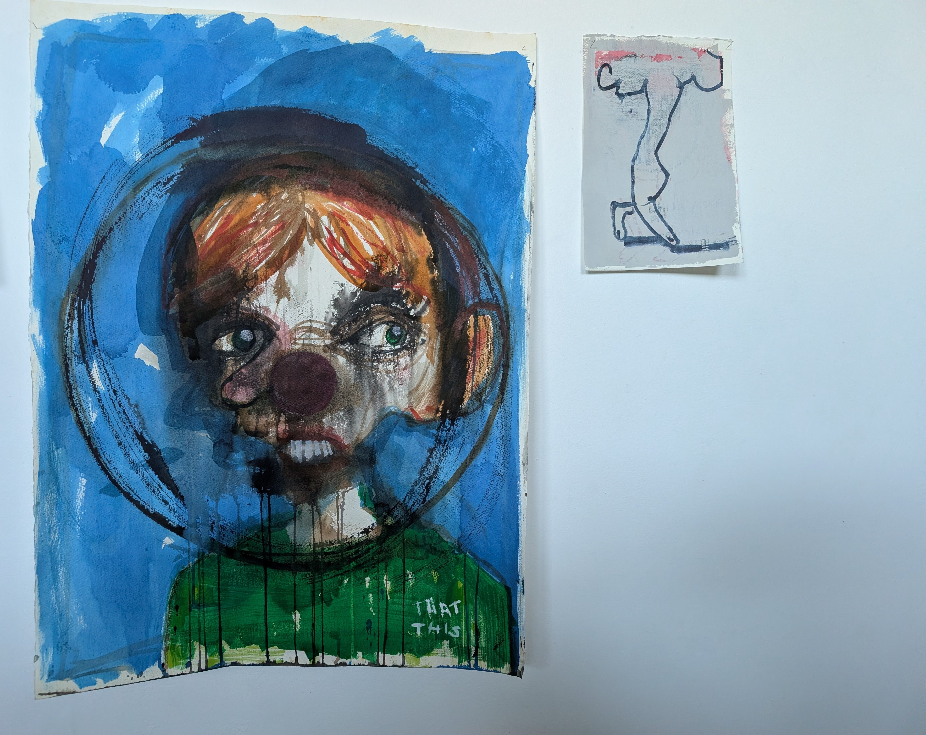 Image of 2 paintings in in the show, a large head in a circle on blue, and a smaller A5 size image of 2 fingers walking from a hand that emerges from a cloud. Blue ink on grey.